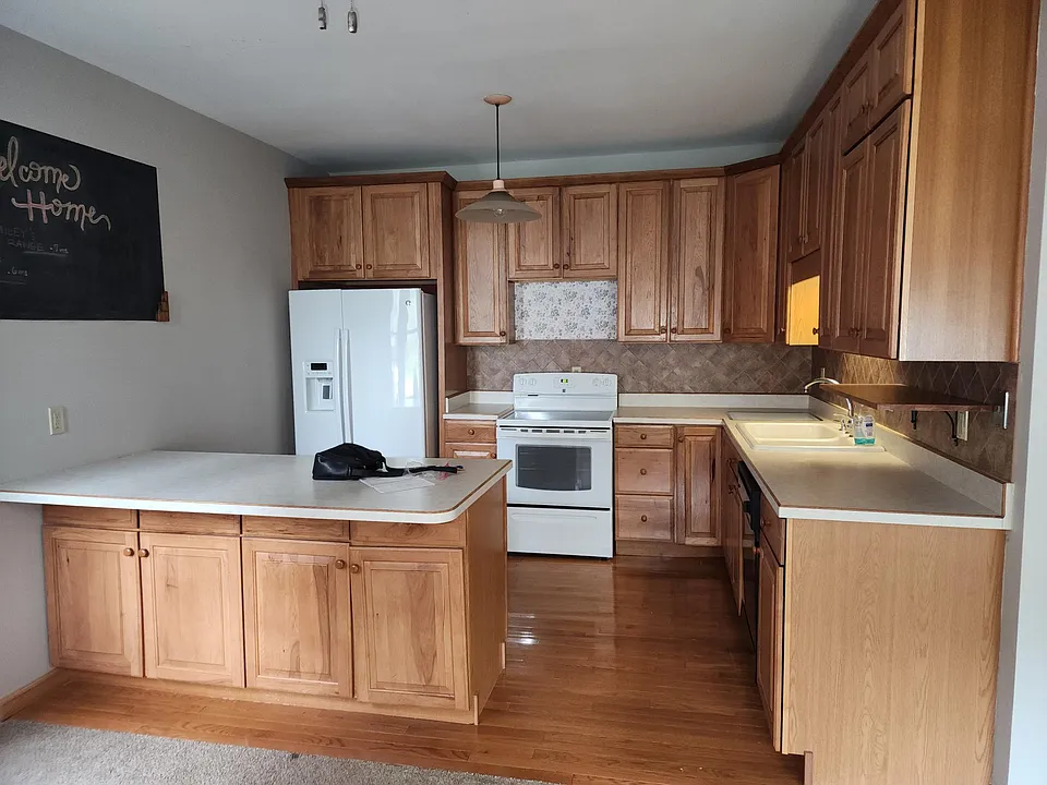 Kitchen on the main level is open to living space. Ceramic top range, side by side refrigerator, built in cutting board, dish washer, shelf for microwave and breakfast bar.