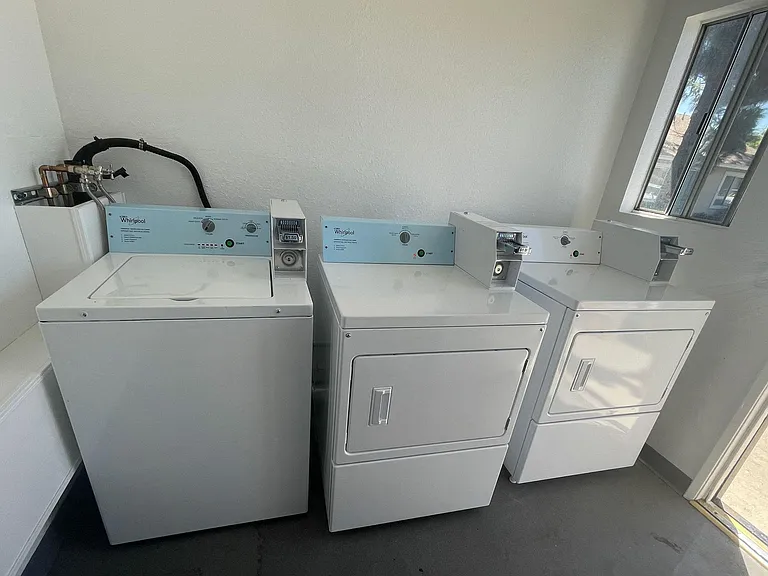 Washing machines and dryers in laundry room at Eucalyptus Apartments in Moreno Valley, California.