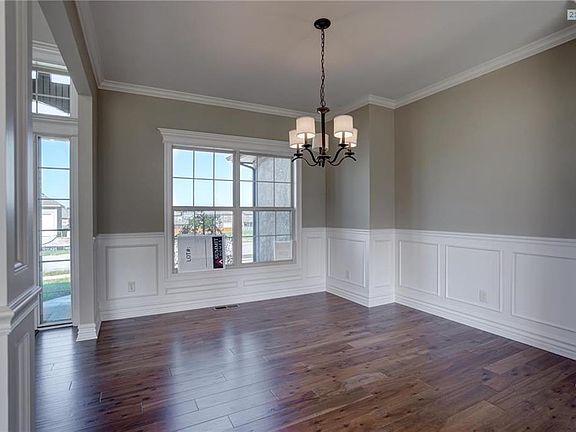 Formal dining or flex room with wainscoting and hardwood flooring.