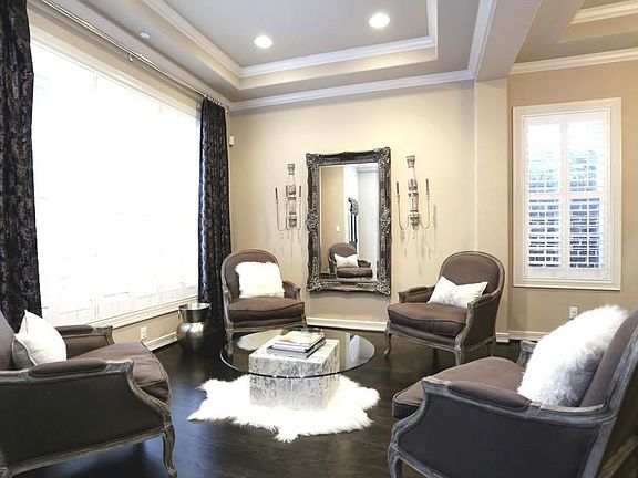 Beautiful living room with gleaming hardwood floors, triple crown molding, plantation shutters and r