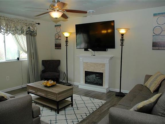 Living room with wood floors, fireplace, and huge windows