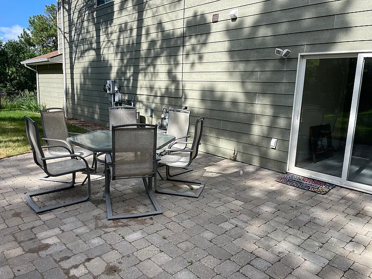 Stone patio area in backyard.