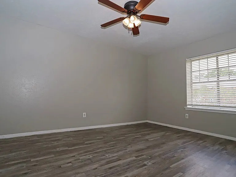 Open-concept living area with wood-style flooring and natural light throughout.