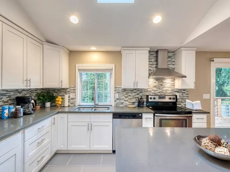 Newer, modern kitchen with new quartz counter top and stainless steel appliances