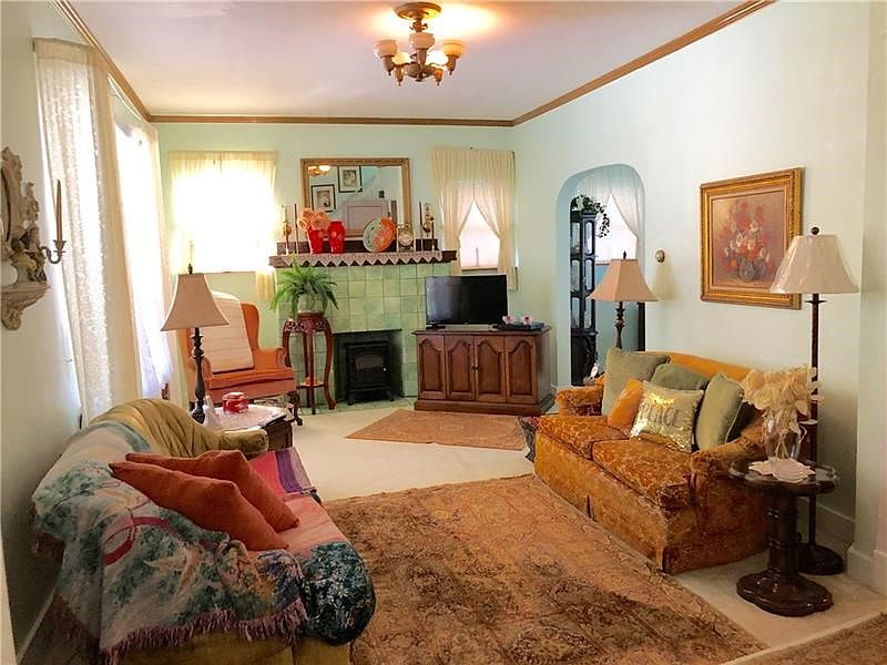 Original tile fireplace adds charm and is the main focal point in this grand living space.
