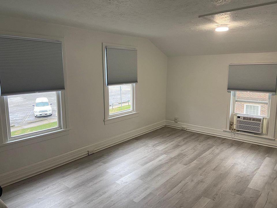 Living room with new vinyl hardwood floors. Lots of natural light streams in. New cellular shades to keep cool in summer, warm in winter. AC unit for extra cooling.