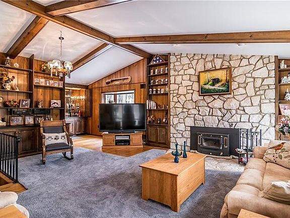 This family/great room is straight out of a luxury resort property with its wood stove, stone fireplace, vaulted & exposed beam 