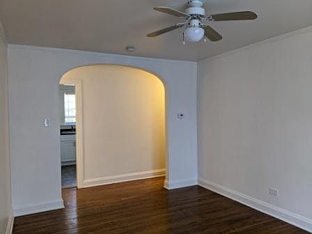 Living room looking toward lit entrance hallway then kitchen