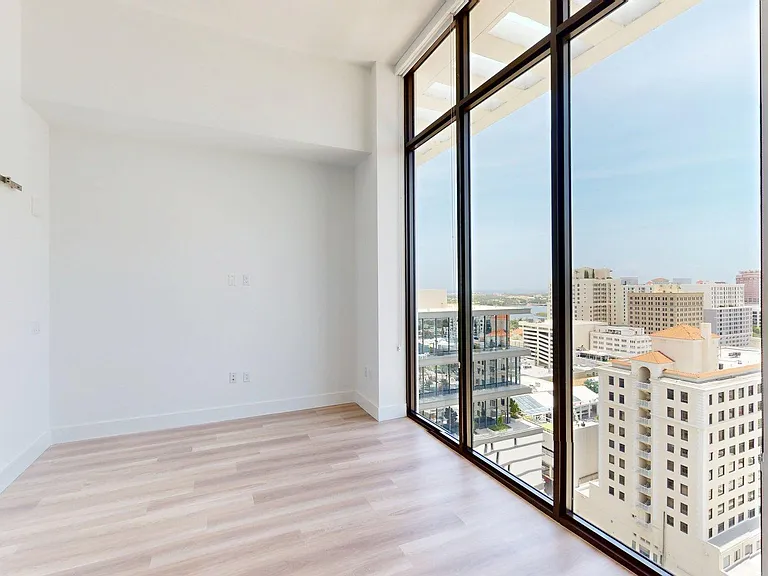 Apartment Living Room with Floor length windows and light wood panel flooring.
