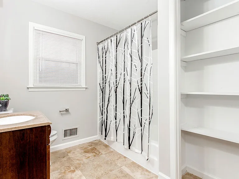 Upstairs shared bath. Tub/shower combo. Storage shelves.