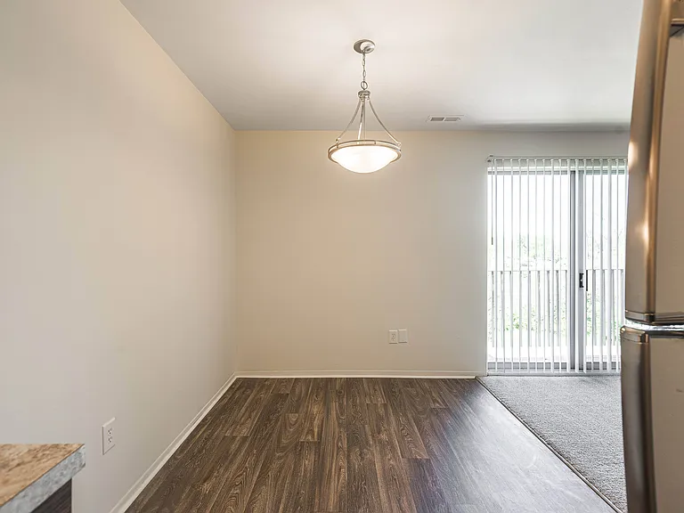 Spacious dining room with natural light and hardwood floors at Knottingham Apartments in Clinton Township, MI