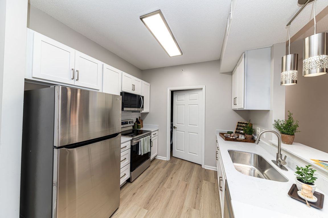 Kitchen with quartz counters, modern cabinetry, & stainless appliances