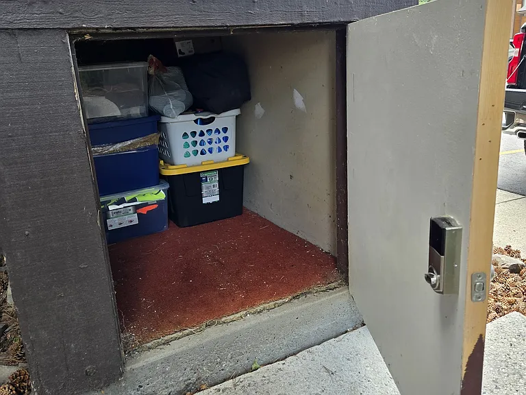 Additional storage compartment just outside the front door under the steps landing with a keypad lock