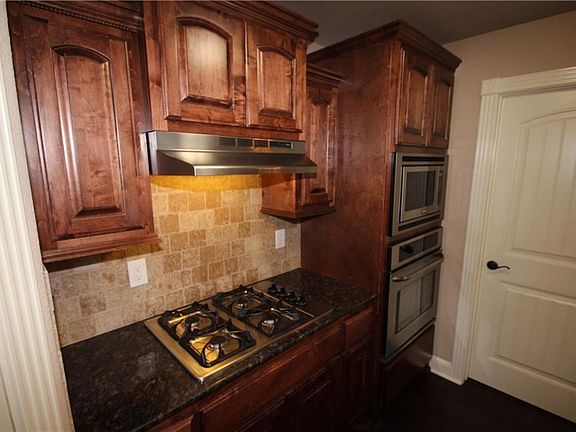 Gas Cooktop with laundry room and Garage access through door on right.
