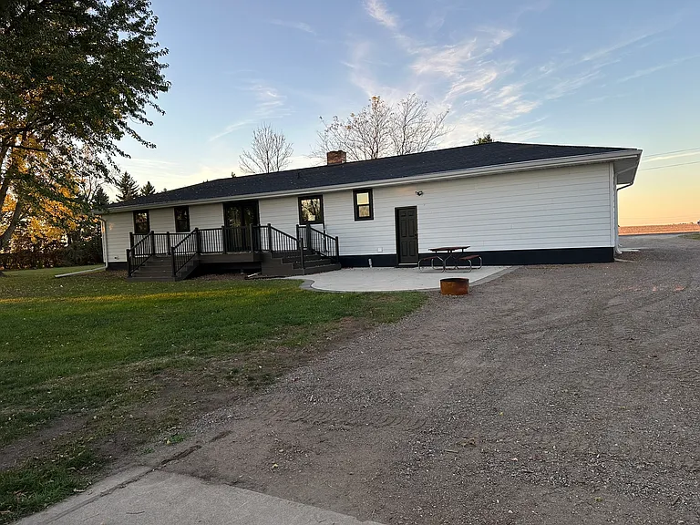 Back of home with patio sliding door, deck, and cement patio area.