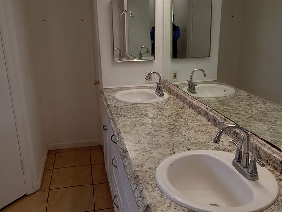 Master Bathroom with double sink, new vanity, linen on wall behind medicine door with double closets.