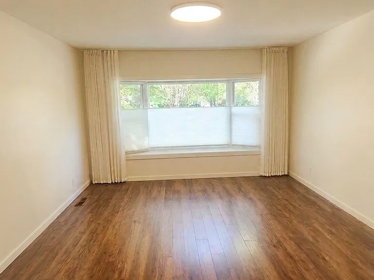 Master bedroom. South-facing / street-facing with custom, light-filtering, up/down privacy blinds and ceiling-track linen curtains.