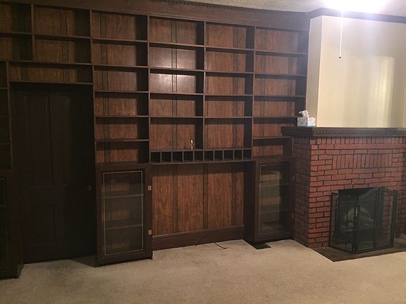 Floor to celling book case next to gas fire place