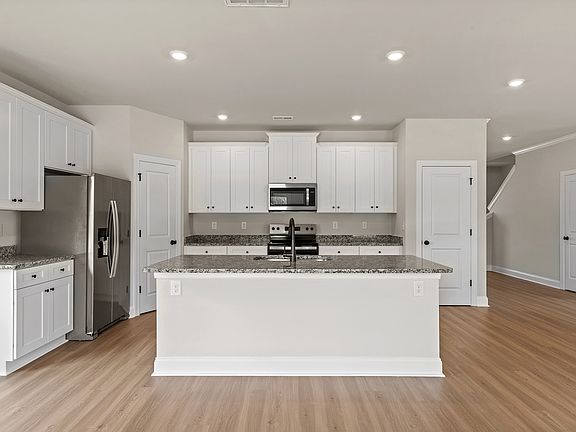 The kitchen has designer wood cabinetry