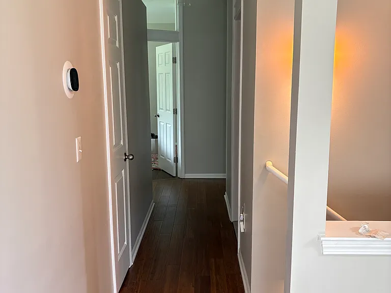 Hallway from living room to primary bedroom, main floor bathroom, laundry room, bedroom #3, basement stairs, and garage