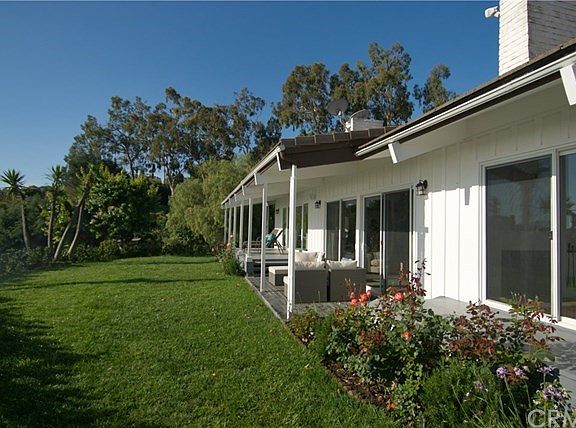 Landscaped yard has a large number of mature fruit trees.