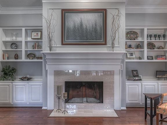 Beautiful fireplace is flanked by built-in book shelves.  The cabinets below have pull out drawers for easy access and storage