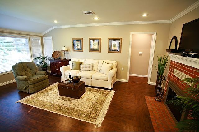 The living room features a bay window and brick hearth fireplace