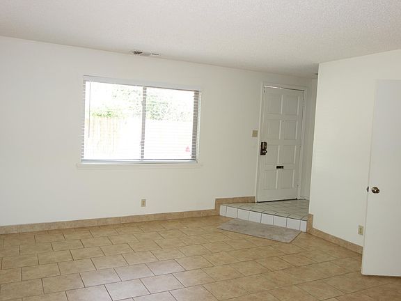 Tiled living room view looking towards the front door.