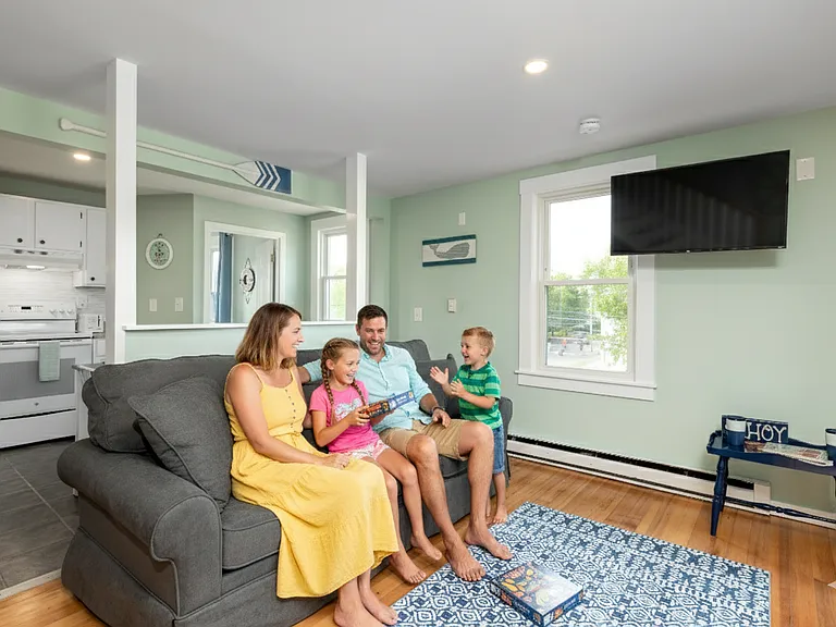 Relax and unwind after a day of exploring! Our comfortable, open-concept living room features a plush sofa, a large smart TV for movie nights, and a cheerful, coastal-inspired design. It's the perfect spot for family games and quality time.