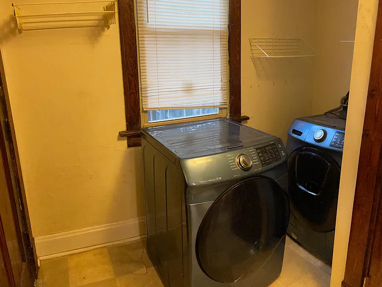 Maytag washer and dryer behind the kitchen with a pull-out drying rack and a window