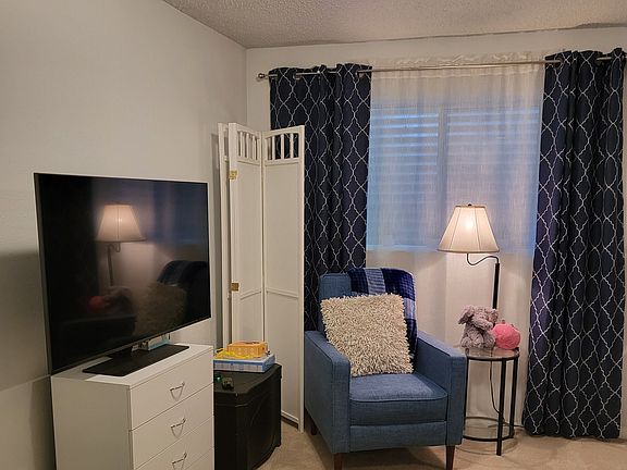 Basement window, recliner, T.V., dresser, end tables, lamps and cheerful decor. 
Room divider to separate bedroom from work space/living area. (Optional)