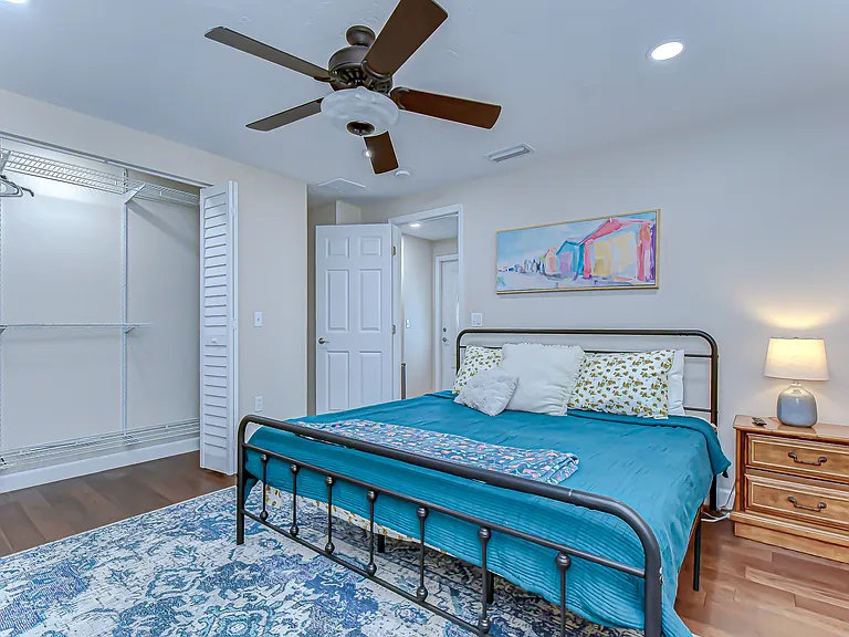 The bedroom features a large king bed, end stand and closet