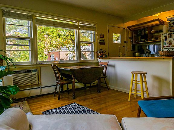 Living room, with wonderful natural light and a view of the church across the street, as well as a long wooden bar/counter-top.