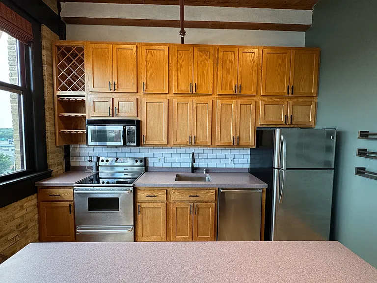 Custom second tier cabinets offer tons of storage for things not used everyday. Step ladder included next to fridge. Matching tile backsplash