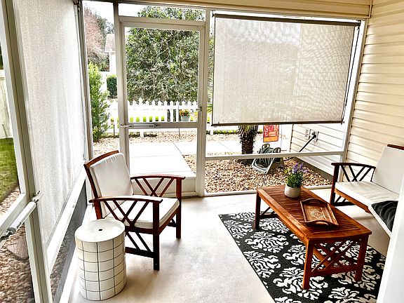 Front patio screened porch with ceiling fan and sun shades.