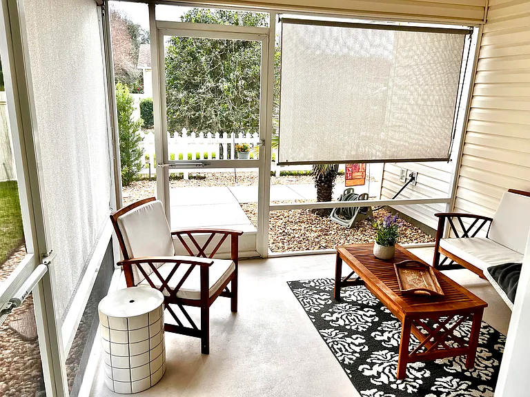 Front patio screened porch with ceiling fan and sun shades.