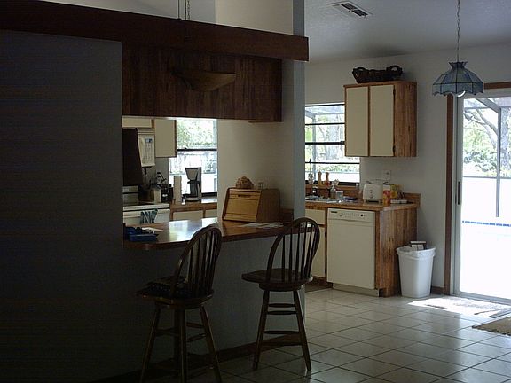 Kitchen has tile flooring, sliding glass doors and a pass thru window 