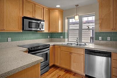 Amazing attention to detail here with Maple cabinets, glass tile backsplash and stainless steel appl