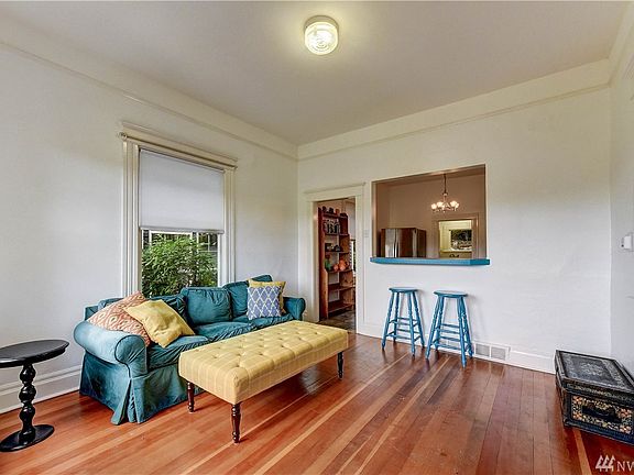 Enter into the living room with 10 ft ceilings and look through to the kitchen. 