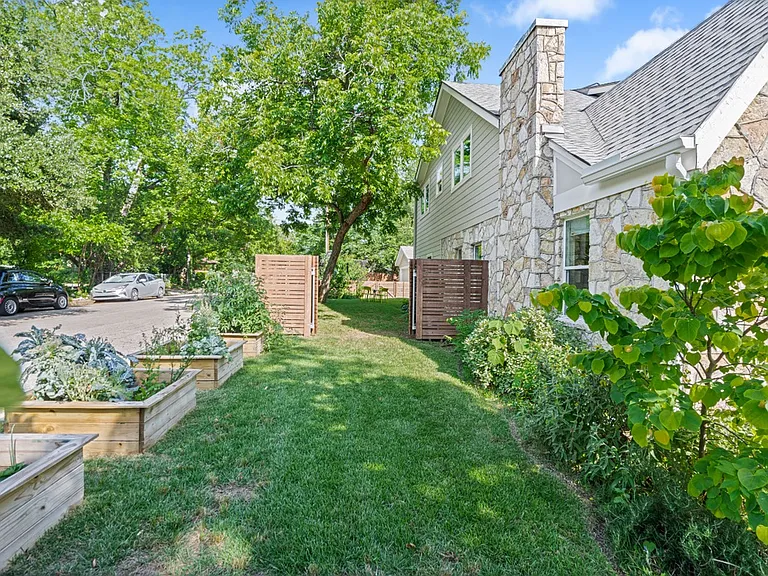Exterior highlighting fenced in yard and raised garden beds.