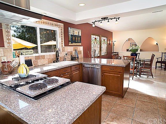 The granite kitchen offers loads of cabinet storage, stainless appliances, recessed lights, and a dining room area.