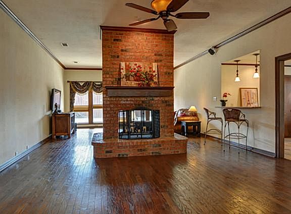 Grand Formal Living Room with Hardwood Floors, Rich Crown Moulding & Dramatic See-thru Fireplace!