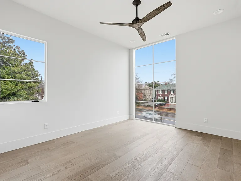 Bright bedroom with large windows, natural light, and modern finishes.