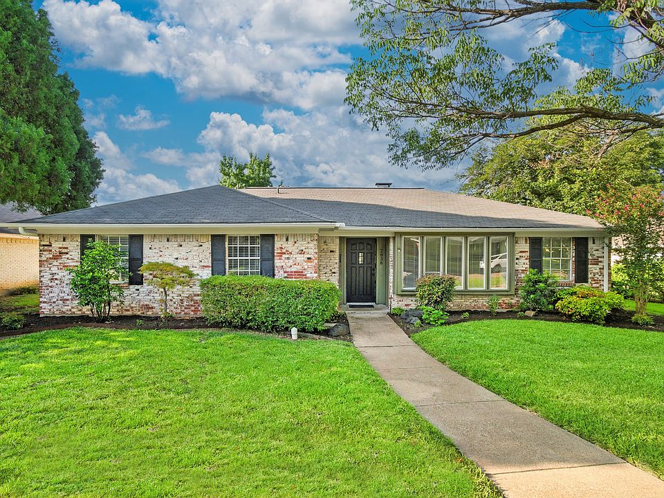Ranch-style home featuring roof with shingles, a front lawn, and brick siding