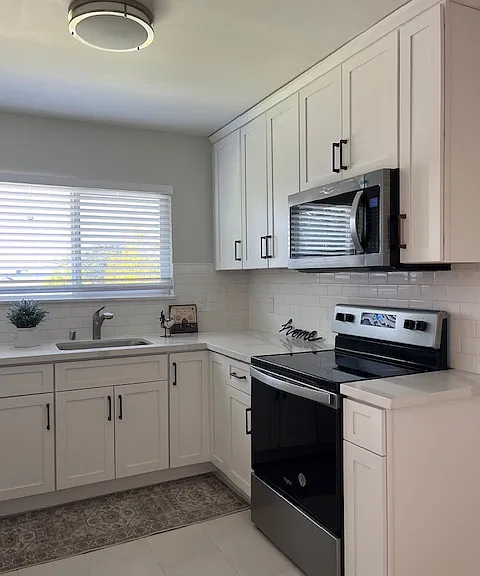 Beautiful new eat-in kitchen has white maple shaker cabinets, quartz counter 
white tile floors, white subway times, stainless steel appliances including electric stove, microwave, dishwasher, refrigerator, LED lighting. Natural light through the window.