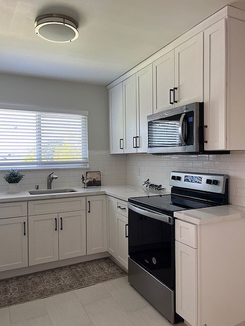 Beautiful new eat-in kitchen has white maple shaker cabinets, quartz counter 
white tile floors, white subway times, stainless steel appliances including electric stove, microwave, dishwasher, refrigerator, LED lighting. Natural light through the window.