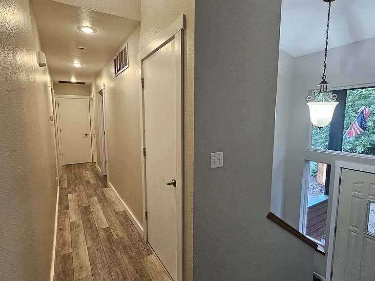 Hallway to upstairs bedrooms, primary suite and 2 full baths plus hallway linen closet.