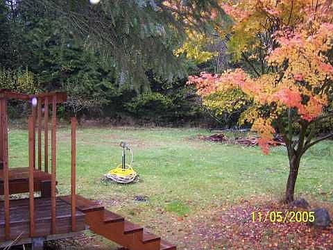 Fenced lower field w/ firepit and deck off garage