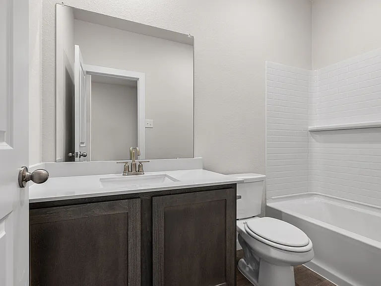 The secondary bathroom has a vanity space and a shower-tub combo.