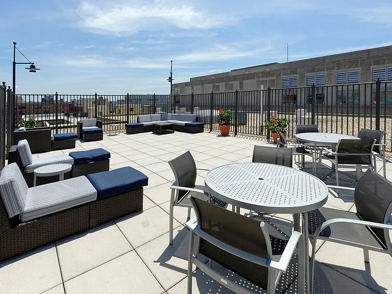 Rooftop lounge chairs and table seating area, facing towards E and 20th Streets